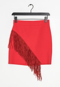 Red mini skirt with a side fringe detail; smooth texture and fitted design, hanging on a black hook against a white background.