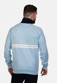 Lichtblauwe sweatshirt met een marineblauwe kraag, voorzien van witte horizontale strepen op de rug. Zacht materiaal en geribde manchetten.