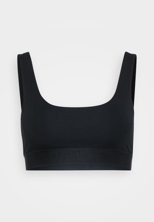 Black seamless sports bra with wide straps and a fitted elastic band featuring a subtle "GAP" logo on the front center.