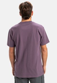 Short-sleeve t-shirt in muted purple cotton, featuring a crew neckline and a relaxed fit with a smooth texture. No patterns or hardware visible.