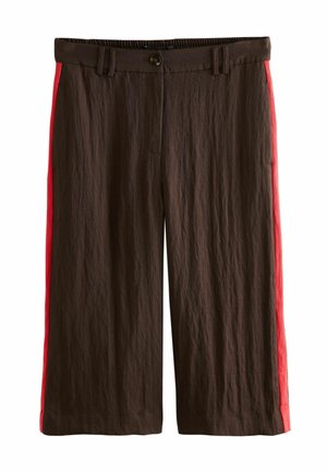 Braune Hose mit weitem Bein, roten Streifen an den Außenseiten, vorn mit Knöpfen und Gürtelschlaufen, vor weißem Hintergrund dargestellt.