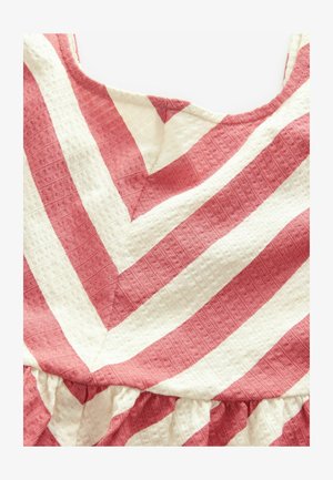 Červenobiely pruhovaný textil s textúrovaným povrchom, ktorý obsahuje vzor v tvare šípky a na spodnom okraji má zhrnutú volánovú ozdobu.