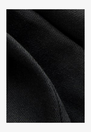 Černá látka s hladkou strukturou, zobrazující detailní pohled na propletené nitě, s matným povrchem a mírným leskem.