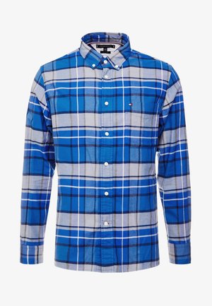 Camisa de hombre de manga larga con botones, con un patrón de cuadros en azul, gris claro y blanco, y un bolsillo en el pecho con un pequeño logo.