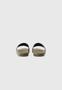 Olive green slide sandals with a textured sole, open back, and two curved straps, featuring a minimalist design and smooth finish.