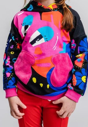 Kolorowa bluza z kapturem z odważnym graficznym wzorem twarzy w odcieniach różu i niebieskiego, z kwiatowymi wzorami na czarnych rękawach. Przednia kieszeń w różowym zamszu.