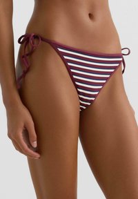 Stribet bikiniunderdel med justerbare bindesider i en farvekombination af rødbrun, hvid og blå samt et tekstureret stofdesign.