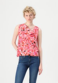 Uten ermer rosa blomstret topp med cowl-hals, myk stoff og flytende design, og en blanding av røde, oransje og svarte mønstre.