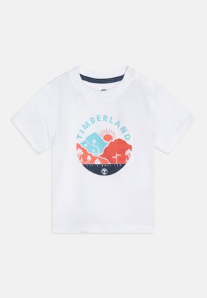 Witte katoenen T-shirt met korte mouwen, voorzien van een ronde grafische print in blauw, rood en zwart, en twee drukknoopjes bij de schouders.