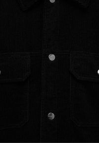 Camicia in corduroy nera, con righe verticali, due tasche frontali con pattina e bottoni in metallo argentato con il marchio "PULL&BEAR".