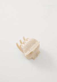 Clips per capelli a forma di conchiglia in plastica rosa pallido con dettagli dorati e piccole decorazioni ornate sui lati. Quattro denti per una presa sicura.
