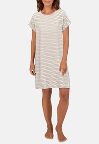 Kurzes Kleid aus leichtem Stoff mit einem geometrischen Wellenmuster in Grün und Pink auf weißem Hintergrund; knielange Schnittform.