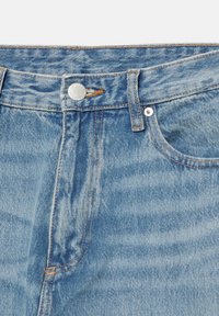 Jean en denim bleu clair avec une taille haute, des coutures cuivrées, une fermeture à bouton argenté et des passants de ceinture. Comprend des poches et une texture douce.