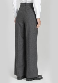 Szerokie szare spodnie wykonane z fakturowanej tkaniny, z subtelnym wzorem, z gładką talią i tylnymi kieszeniami.