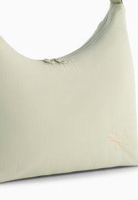 Lys grøn håndtaske med en glat overflade. Har en buet form, lynlåslukning og et diskret guld broderet logo.