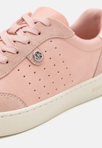 Ljusrosa sneaker med perforerat ovandel, mocka- och läderstrukturer, rund silverfärgad logotyp och en krämfärgad gummisul.