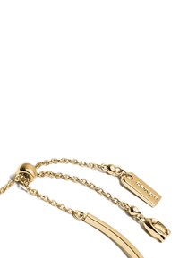 Gold-colored necklace featuring a smooth, curved chain with small, round links and a branded clasp with a rectangular tag.