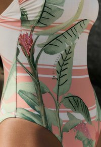 Eén stuk badpak met een bloem- en bladerenprint in groen en roze, met witte strepen en een zachte, gladde textuur.