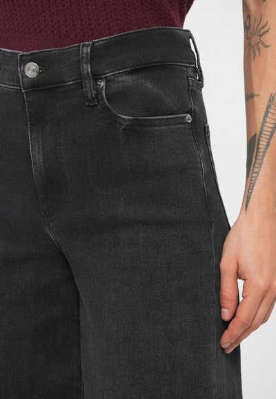 Jeans pretos de cintura alta feitos de ganga, com um design clássico de cinco bolsos e um efeito de lavagem subtil ao longo das coxas.