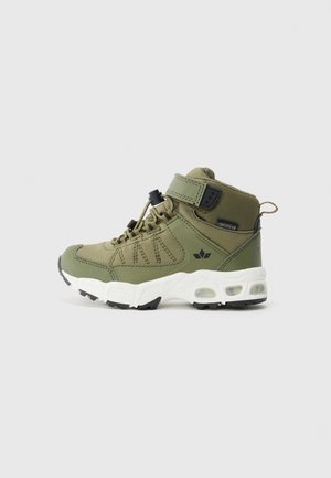 Grønn høy-top sneakers med hvit polstret såle, justerbar stropp, trekkloft, og svart logo på siden, designet for utendørs bruk.
