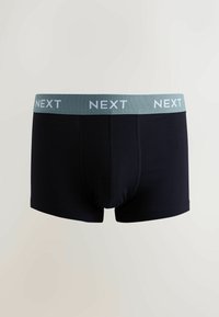 Caleçons pour hommes noirs avec une ceinture élastique vert clair portant le texte "NEXT" en blanc. Tissu lisse, coupe ajustée.