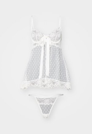 Ensemble de lingerie gris à pois blancs, comprenant un corsage en dentelle transparente, des bretelles réglables et un string en dentelle assorti.