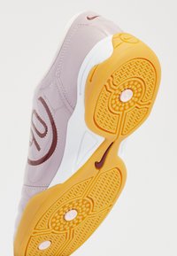Sneaker with a glossy pale lavender upper, white midsole, and bright yellow rubber outsole featuring a textured pattern for grip.