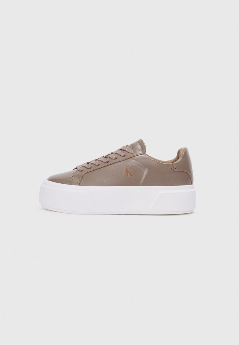 Beige lærersneakers med avrundet tupp, hvit plattformsåle og brune snører. Har et lite logo på siden. Minimalistisk design.