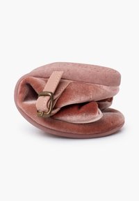 Bolsa de terciopelo en rosa suave con un acabado texturizado, que presenta una correa rosa clara y herrajes de bronce, forma redondeada y diseño compacto.