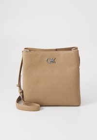 Tan crossbody torba z vzorcem v odtisu, srebrno kovinsko logo opremo in nastavljivim trakom. Pravokotna oblika z gladko teksturo.