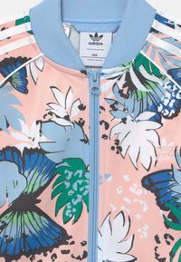 Floral zip-up bomber jacket in pink, featuring blue accents, a ribbed collar, and vivid green and blue leaf patterns. Adidas logo on front.