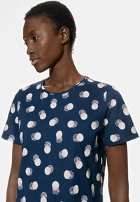 T-shirt bleu marine en coton, avec un motif de formes circulaires en rose et blanc. Manches courtes et encolure ras du cou.