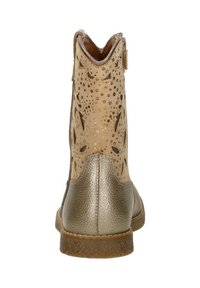 Tan enkelboot met perforaties en metallic gouden accenten. Heeft een gestructureerde, glanzende achterkant en een platte, duurzame zool.
