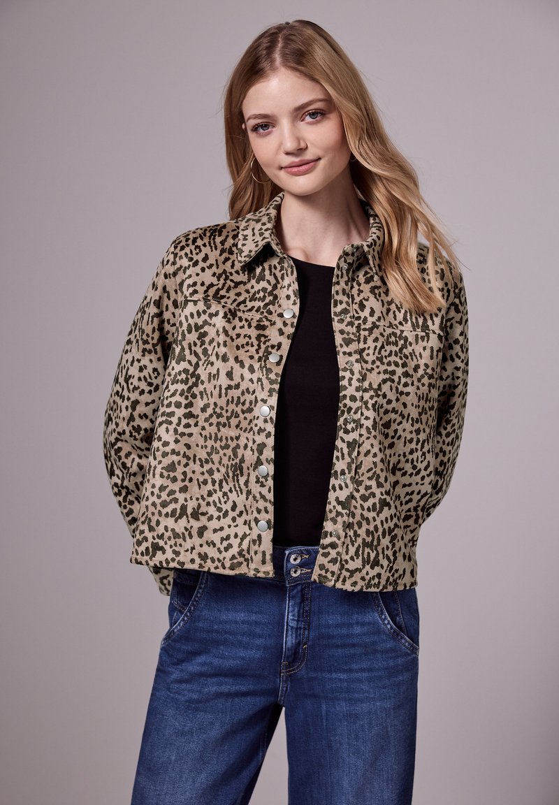 Veste en tissu doux à imprimé léopard, avec un devant boutonné, un col pointu et deux poches poitrine. Associée à un jean dark.