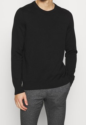 Schwarzer Rundhalsausschnitt-Pullover aus strukturiertem Strickstoff. Mit gerippten Bündchen und Saum, sowie einem kleinen Logo-Element auf der Brust.