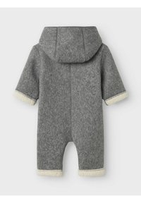 Combinaison en polaire grise avec capuche, présentant des poignets et des coutures en fausse fourrure de couleur claire. Jambes courtes et design simple sans motifs.