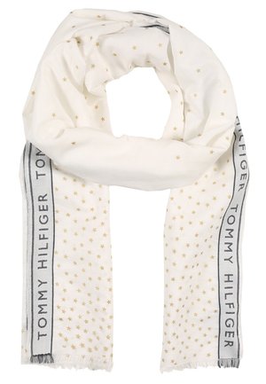 Biały szal z wzorem małych złotych gwiazdek i napisem "Tommy Hilfiger" wzdłuż krawędzi z czarną obwódką, z frędzlami na końcach.
