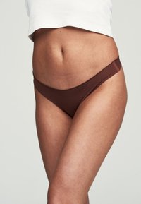 Brauner Bikiniunterteil mit glatter Textur, niedriger Schnitt und minimaler Abdeckung. Verfügt über dünne Seitenträger für ein schlankes Design.