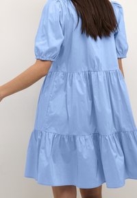 Ljusblå klänning i mjukt tyg, med korta puffärmar, en flera lager design och insamlad midja, som ger en avslappnad silhuett.