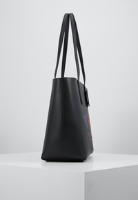 Sort læder shoppertaske med tekstureret finish, aflang form og to lange hanke, med farverige grafik på den ene side.