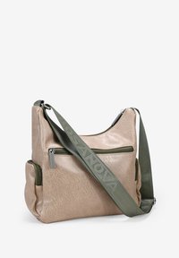 Bolso de hombro de imitación de cuero beige con un acabado texturizado, dos bolsillos con cremallera y una correa de hombro verde con texto en relieve.