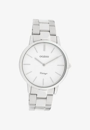 Montre-bracelet en métal argenté avec cadran rond blanc, marqueurs horaires minimalistes et deux aiguilles indiquant l'heure 10:10, marque OOZOO Vintage.