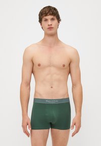Boxer-briefs vert foncé avec une ceinture grise portant le texte "Marc O'Polo". Fabriqués en tissu doux, ils ont une coupe ajustée.