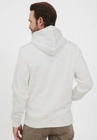 Hvid hætte sweatshirt med en blød tekstur, ribbede manchetter og kant, samt en kengurulomme. Designet med en afslappet pasform og minimale sømme.
