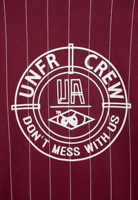 Bordo marškiniai su dideliu baltu apskritimu, kuriame yra tekstas "UNFR CREW UA" ir akies ikona, išdėstyti su vertikaliomis baltomis juostelėmis.