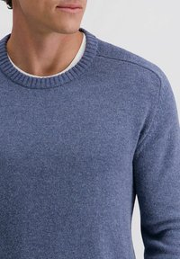 Crewneck-Pullover aus meliertem blauen Strickstoff; mit geripptem Kragen und Bündchen, glatter Textur und minimalen Nahtdetails.