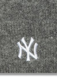 Gorro de punto gris con un prominente logotipo blanco bordado en la parte frontal, con una textura suave y un ajuste ceñido.