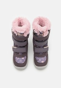 Purpurovi batai su rožiniu dirbtinio kailio apvadu, širdelės raštai rožinės ir liliaus spalvos, sustiprinta kojos dalis, reguliuojami Velcro diržai ir guminiai padai.