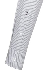 Gestreifte Hemdsärmel in Weiß und Marineblau, mit einer Knopfmanschette mit zwei Knöpfen und einem gestickten Rosenlogo in der Nähe des Handgelenks.