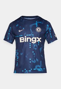Blå og marineblå fodboldtrøje lavet af glat stof, med blå grafiske mønstre, en rund krave, Nike-logo og teksten "Bingx".